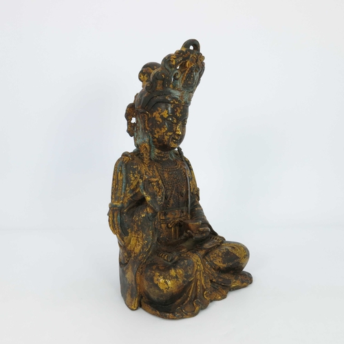 460 - A large Chinese gilt bronze figure of a deity, seated cross legged and wearing a headdress, mounted ... 