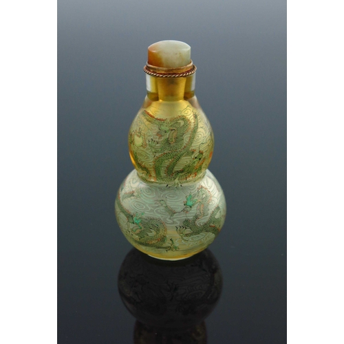 462 - A Chinese double gourd clear glass snuff bottle, internally painted with dragons amongst clouds chas... 