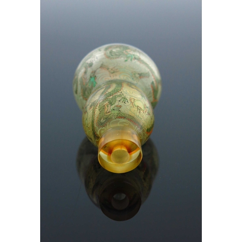 462 - A Chinese double gourd clear glass snuff bottle, internally painted with dragons amongst clouds chas... 