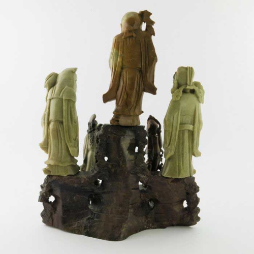 470 - A Chinese soapstone carving, in the form of five robed figures mounted upon a rocky outcrop, 34cm hi... 