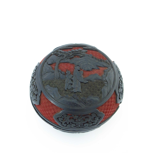 471 - A Chinese red and black lacquer circular covered vessel, carved in high relief with two figures in a... 