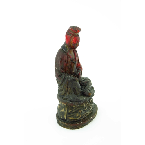 472 - A Chinese moulded red translucent figure of a seated female deity, raised on a lotus leaf, gilt remn... 