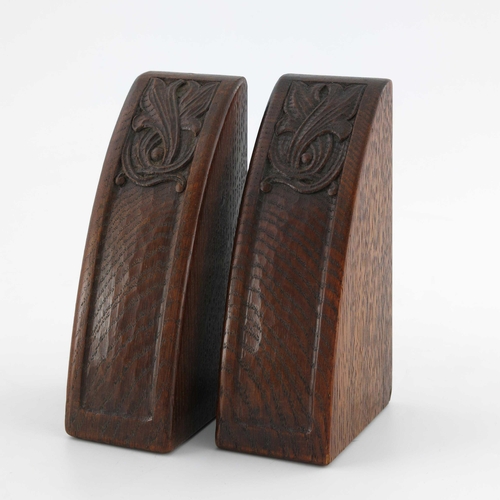 502 - Arthur Simpson of Kendal, a pair of Arts and Crafts carved oak bookends, segment form, adzed and car... 