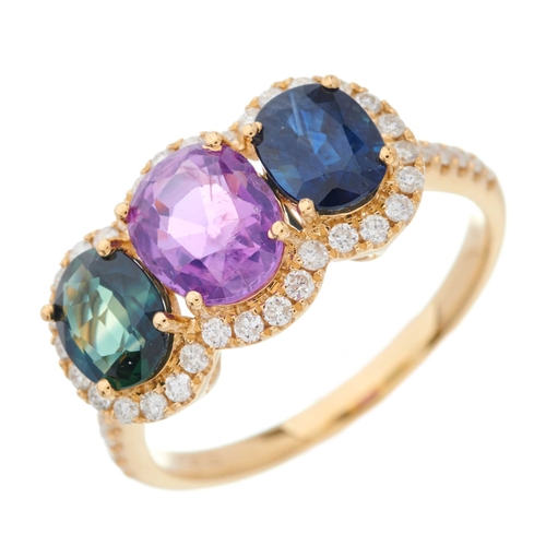 64 - An 18ct gold vari-hue sapphire three-stone dress ring, with brilliant-cut diamond shared surround an... 