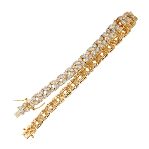 177 - An 18ct gold diamond cluster line bracelet, designed as a series of brilliant-cut diamond quatrefoil... 