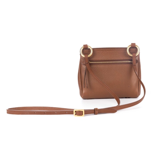 289 - Burberry, a small crossbody saddle bag, crafted from tan leather with bushed gold-tone hardware acce... 