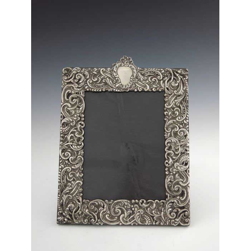 145 - A Victorian silver photograph frame, Charles Dumenil, London 1899, rectangular, embossed in relief w... 