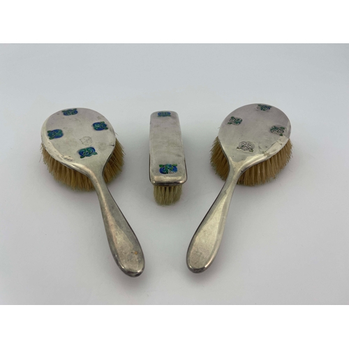 229 - Archibald Knox for Liberty and Co., a set of three Arts and Crafts silver and enamelled brushes, Bir... 