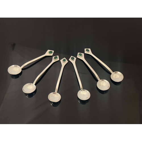 235 - A set of six Arts and Crafts white metal and gem set teaspoons, circa 1905, the planished circular b... 