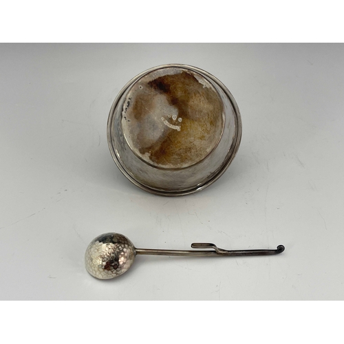 243 - An Arts and Crafts silver sugar bowl and spoon, A E Jones, Birmingham 1924, planished conical pail f... 