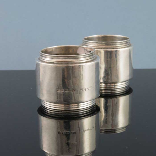 256 - Charles Boyton, a pair of Art Deco silver napkin rings, London 1937, stepped cylindrical form with c... 