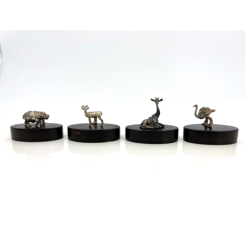 272 - Patrick Mavros, a set of four boxed Modernist novelty silver figural menu holders, oval hardwood bas... 