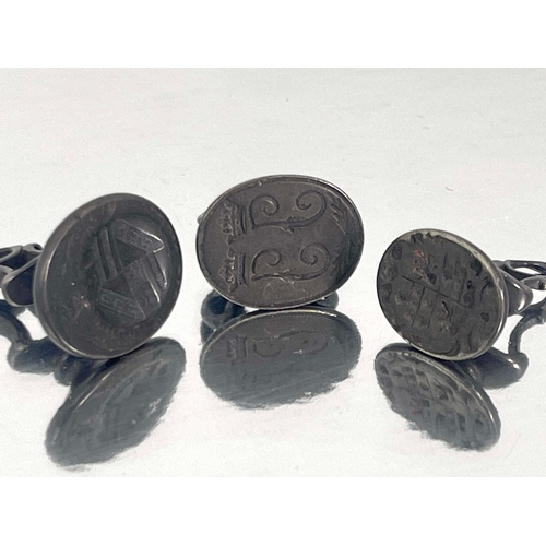 296 - Three Georgian pewter pocket seal fobs, scroll mounts with ring suspension hooks, one with intaglio ... 