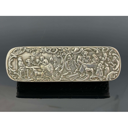 18 - A Dutch silver tobacco box, 1910, oblong rounded form, the lid embossed with tavern scenes within C ... 