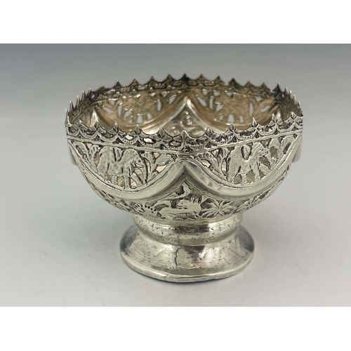 8 - An Indian white metal reticulated pedestal bowl, embossed with forest animals below pierced border o... 