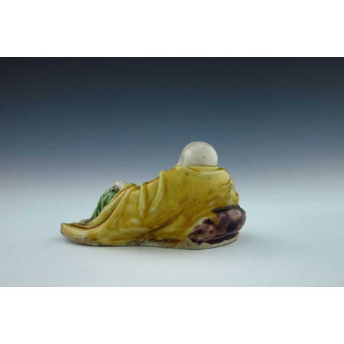 396 - An early 19th Century Chinese porcelain figure of a reclining smiling Buddha, green, yellow and purp... 