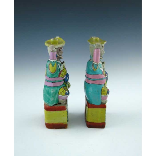 399 - A pair of Chinese coloured enamel porcelain candle holders, in the form of smiling bearded men in ro... 