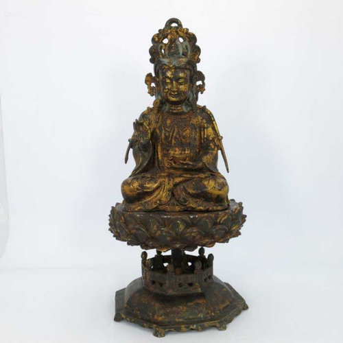 405 - A large Chinese gilt bronze figure of a deity, seated cross legged and wearing a headdress, mounted ... 