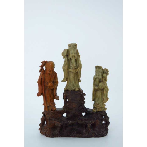 410 - A Chinese soapstone carving, in the form of five robed figures mounted upon a rocky outcrop, 34cm hi... 