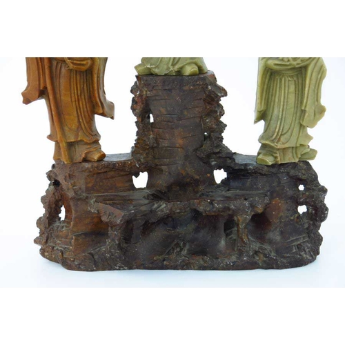 410 - A Chinese soapstone carving, in the form of five robed figures mounted upon a rocky outcrop, 34cm hi... 