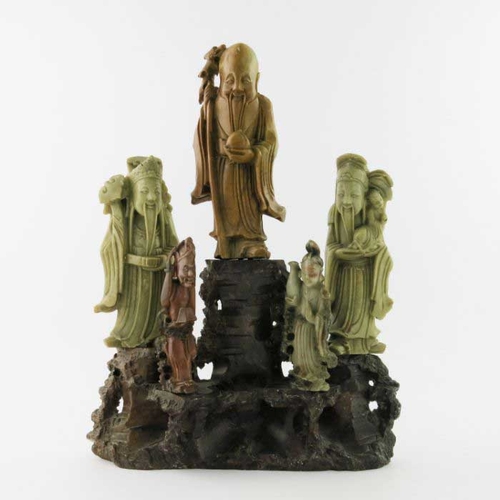 410 - A Chinese soapstone carving, in the form of five robed figures mounted upon a rocky outcrop, 34cm hi... 