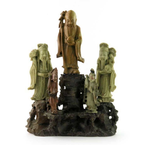 410 - A Chinese soapstone carving, in the form of five robed figures mounted upon a rocky outcrop, 34cm hi... 