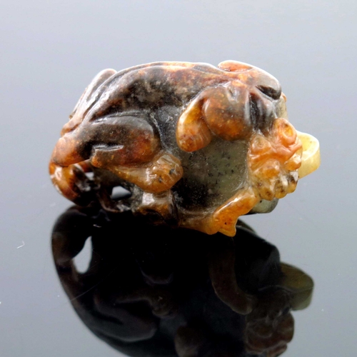 416 - A Chinese jade carving, in the form of a kylin on a rock, russet inclusions, 4.5cm