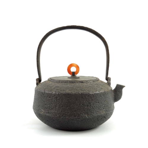 420 - A Japanese cast iron spirit teapot, textured surface with loop swing handle, bronze flat cover with ... 