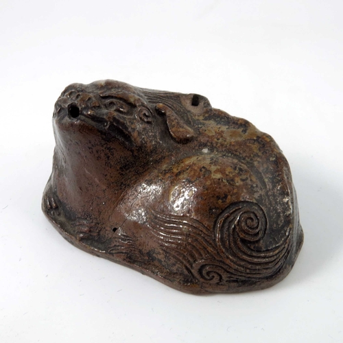 424 - A Chinese stoneware water dropper, Ming dynasty, modelled as a recumbent Buddhist lion or foo dog, 8... 