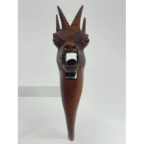 435 - A Black Forest carved wood nut cracker, modelled as a bear, the mouth opening, set with spherical bl... 