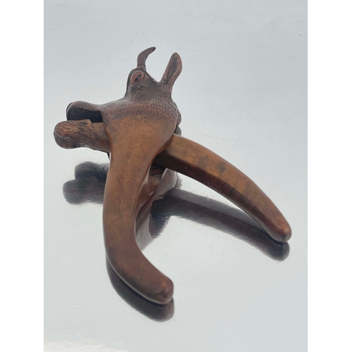 436 - A Black Forest carved wood nut cracker, modelled as a deer, the mouth opening, set with spherical gl... 