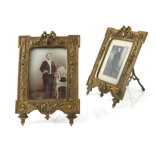 437 - A pair of Victorian gilt metal photograph frames, foliate design with ribbon surmount, splayed legs,... 