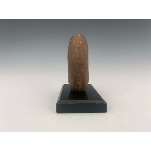 445 - A stone age mace head, of distorted oval form with off-central hole, 9cm high, mounted