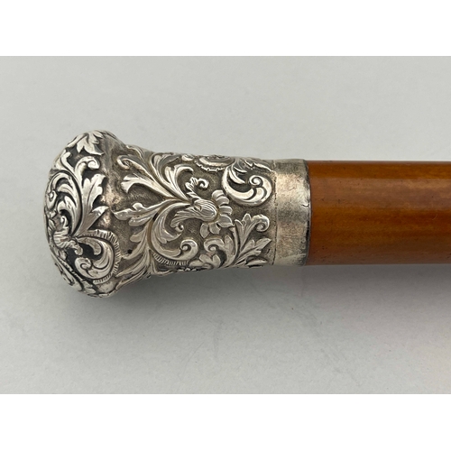 485 - A 19th century white metal topped malacca walking cane, the pommel end embossed and chased with foli... 