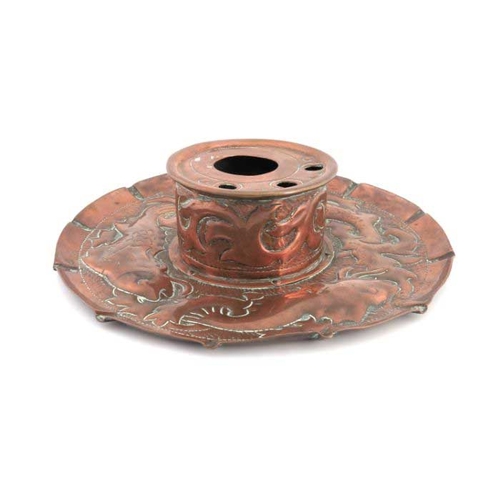 501 - An Arts and Crafts Cornish copper inkwell, Newlyn style, the circular dish repousse decorated with f... 