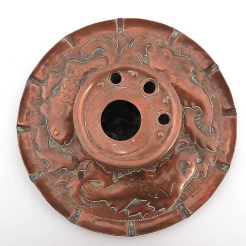 501 - An Arts and Crafts Cornish copper inkwell, Newlyn style, the circular dish repousse decorated with f... 