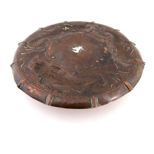 501 - An Arts and Crafts Cornish copper inkwell, Newlyn style, the circular dish repousse decorated with f... 