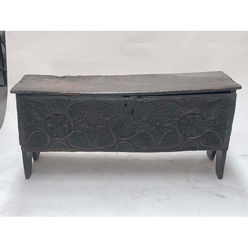 726 - A 17th Century oak plank chest, wire hinges, foliage and floral carved front, stile feet, 56cm high,... 