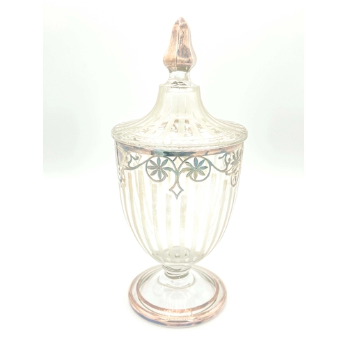 774 - A clear glass bon-bon jar and cover, early 20th Century, of Neoclassical urn design, silver overlaid... 