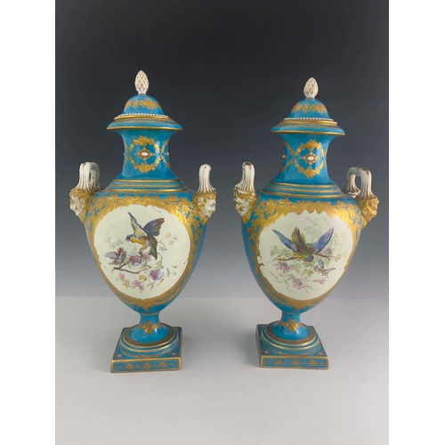 832 - A pair of Sevres style covered twin handled baluster vases, mid 19th Century, pineapple finials to t... 