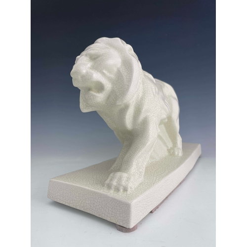 864 - LeJan, Lion Peugeot, an Art Deco ceramic figure, circa 1930, modelled as a striding lion, white craq... 