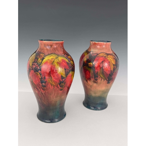 874 - William Moorcroft, a near pair of flambe Leaf and Berry vases, circa 1930, of shouldered form, signe... 