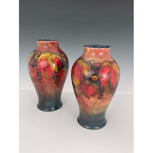 874 - William Moorcroft, a near pair of flambe Leaf and Berry vases, circa 1930, of shouldered form, signe... 