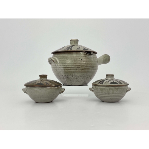 907 - David Leach, a studio pottery soup tureen and cover with two lidded bowls, decorated in wax resist w... 