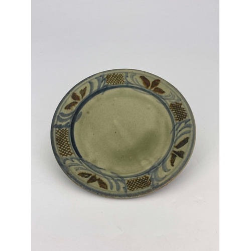 908 - Seth Cardew for Wenford Bridge, a studio pottery plate, celadon glaze and painted to the rim with al... 