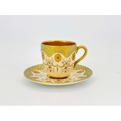 912 - A Coalport jewelled cup and saucer, the gilt ground serpentine borders with graduated turquoise cabo... 