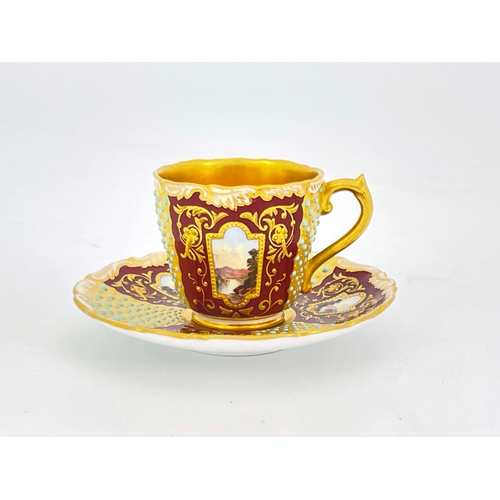 913 - A Coalport jewelled and scene painted cup and saucer, the ogee cup and moulded feather edge saucer d... 