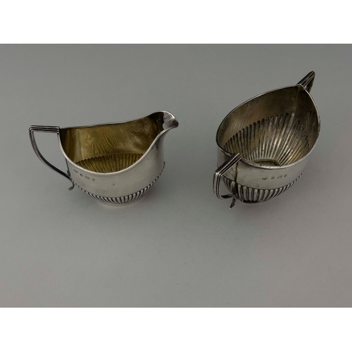 71 - An Edwardian silver jug and bowl, Williams Ltd., Birmingham 1901, half reeded boat form, with angled... 