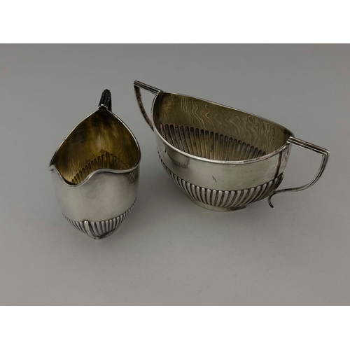 71 - An Edwardian silver jug and bowl, Williams Ltd., Birmingham 1901, half reeded boat form, with angled... 