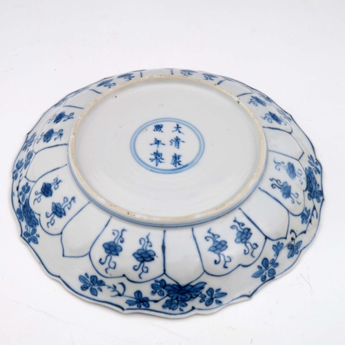 373 - A Chinese blue and white plate, Kangxi mark and probably of the period, ogee rim, painted with alter... 